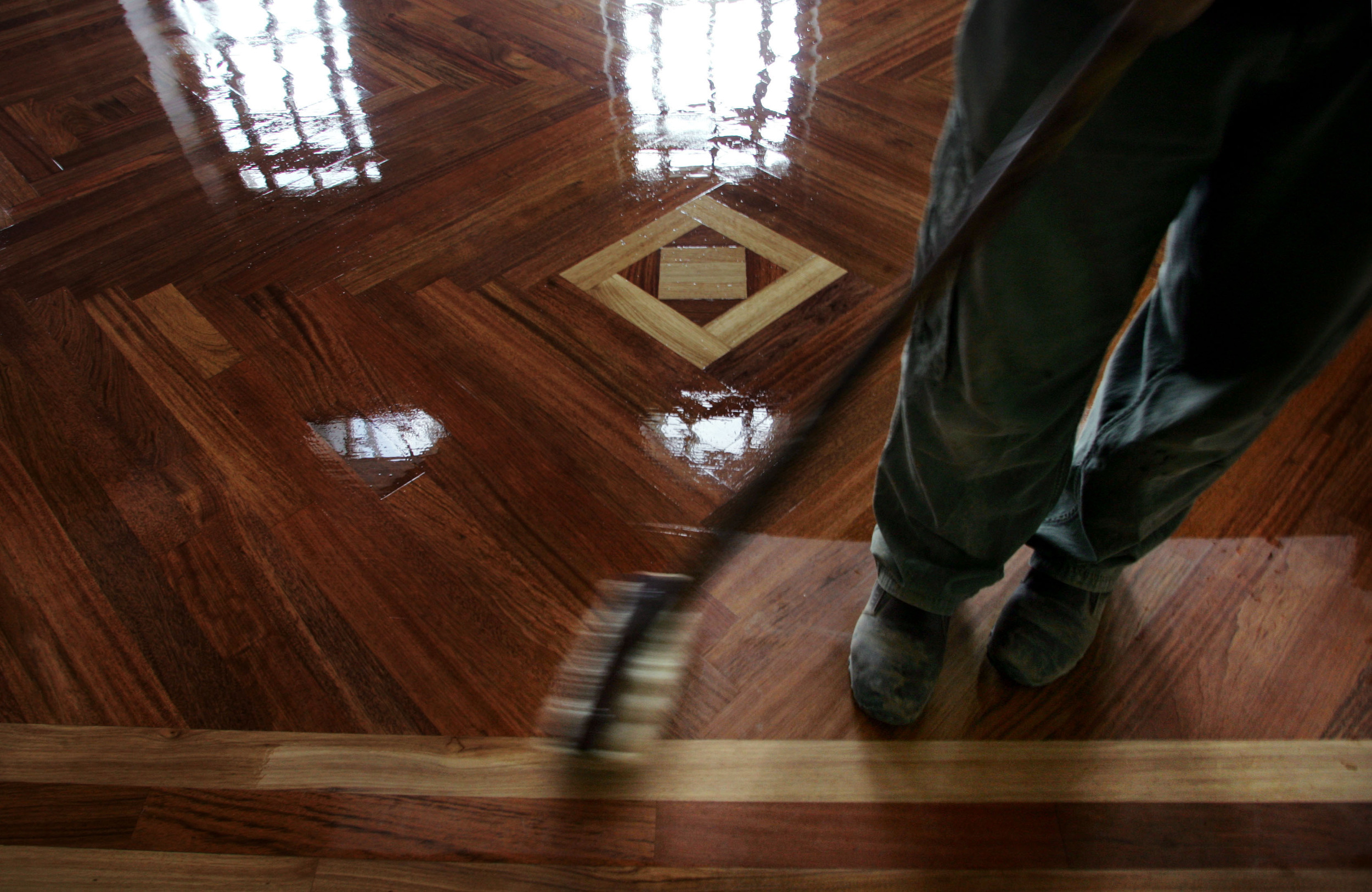  Mark Hollaway of Floor Works adds a final coat of polish onto the Brazilian cherry wood floors. 