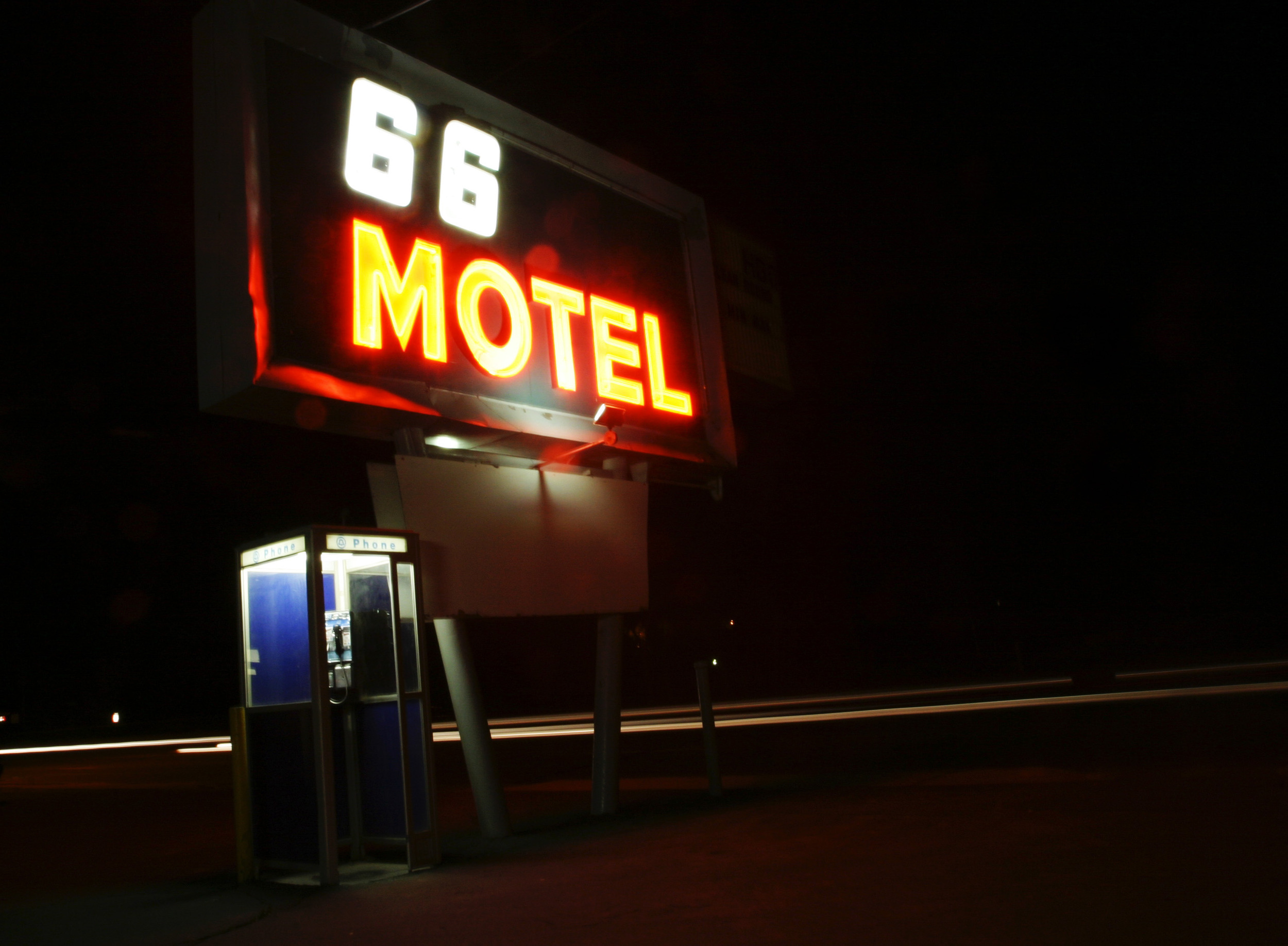  Car headlights mark Route 66 as they go by the 66 motel in Flagstaff, Arizona at night. 