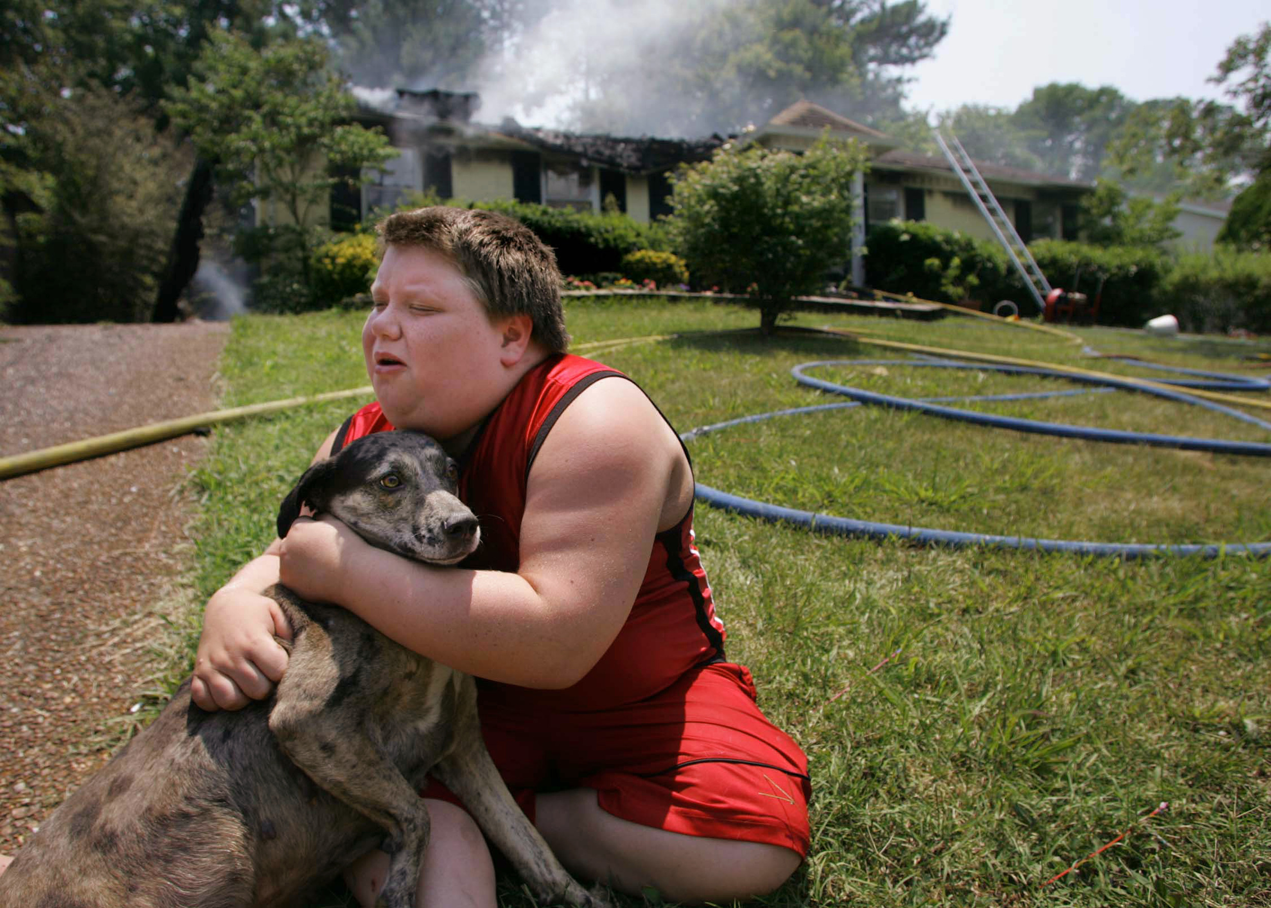  Joseph Cunningham , 11, hugs his dog “Vicious” outside his grandmother’s still-smoking house. He believed the dog had been trapped inside the fire but was found by a neighbor Friday, July 7, 2006 in Antioch, Tenn.  