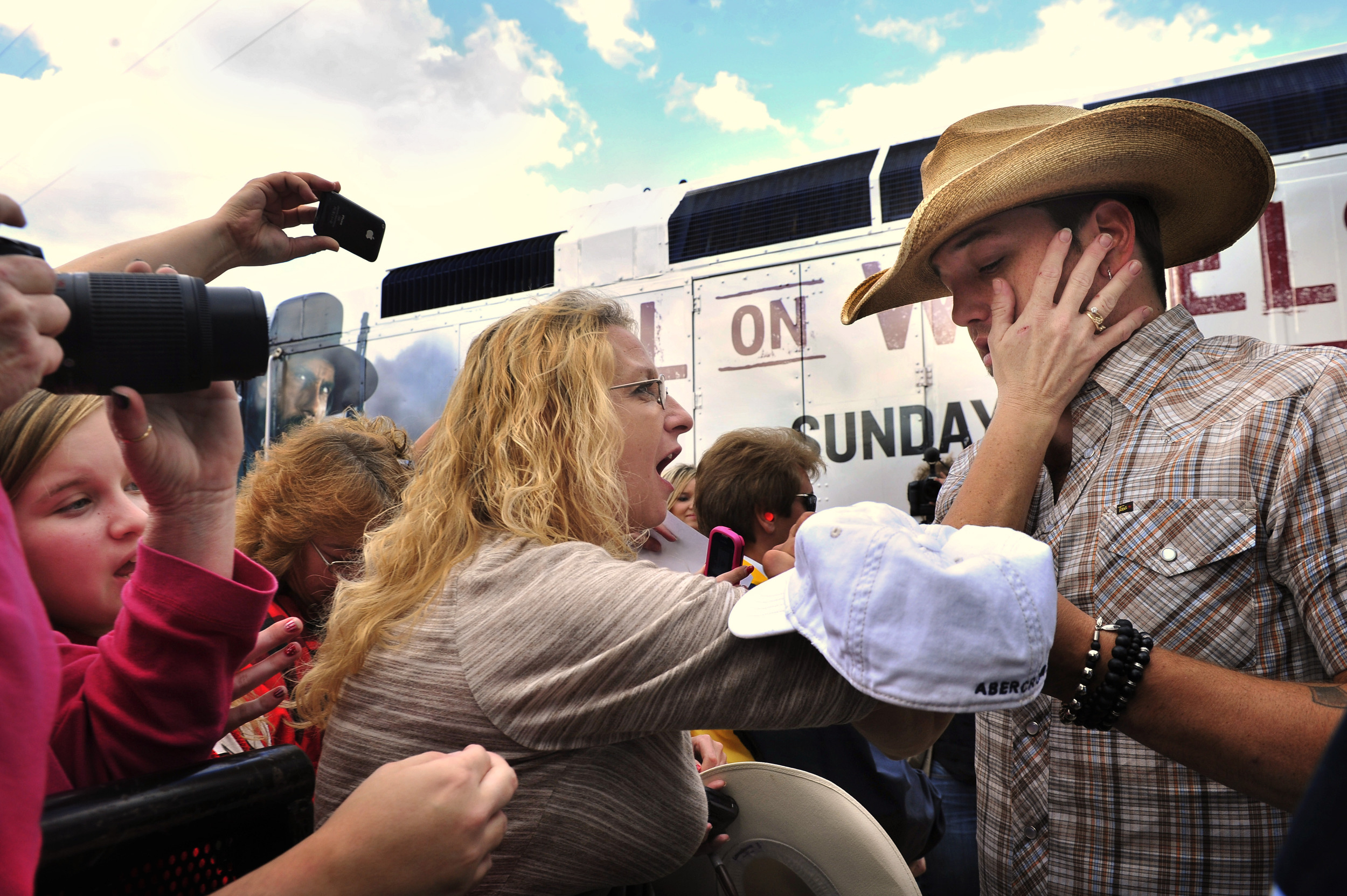  A fan touches Jason Aldean as he signs autographs for fans after a free concert at the riverfront downtown in Nashville, Tenn.  