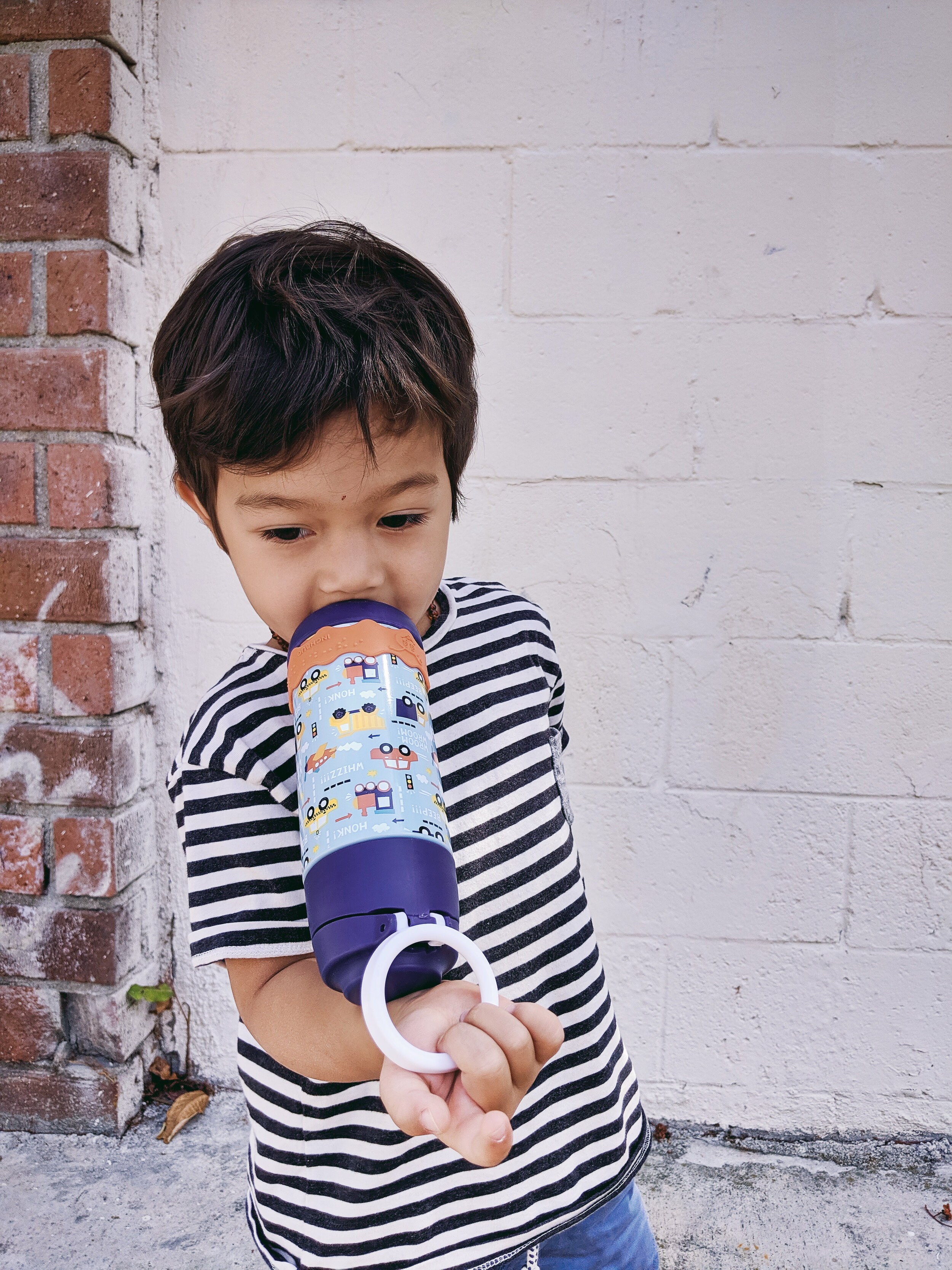 FAMILEE Travel_toddler with water bottle in front of white brick wall_.jpg
