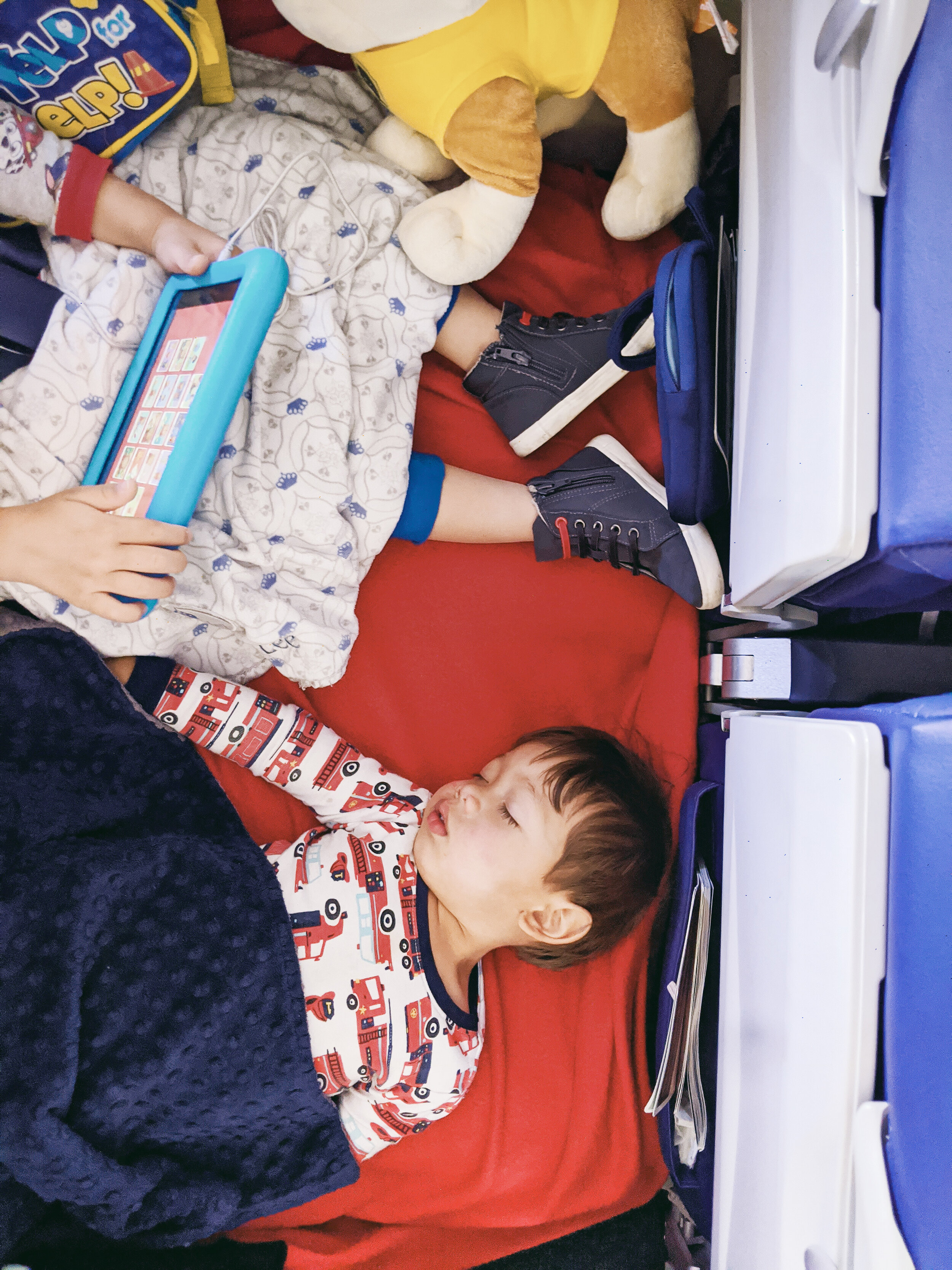Elden (4 years old) relaxing and Orlo (2 years old) sleeping flat using airplane inflatable footrest pillows