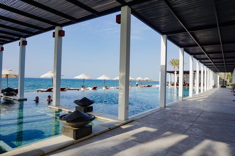 Infinity-pool-ocean-hallway-umbrellas-The-Chedi-Muscat-Oman.jpg