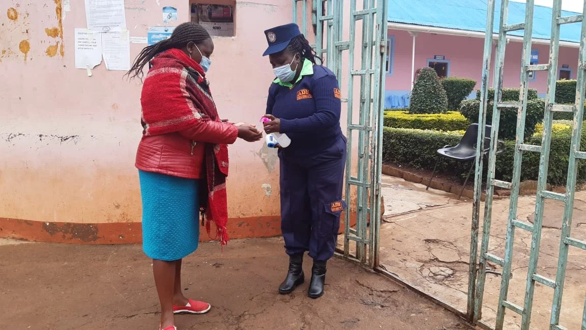 Jane-as-a-security-guard-giving-a-client-an-alcohol-based-sanitiser.jpg