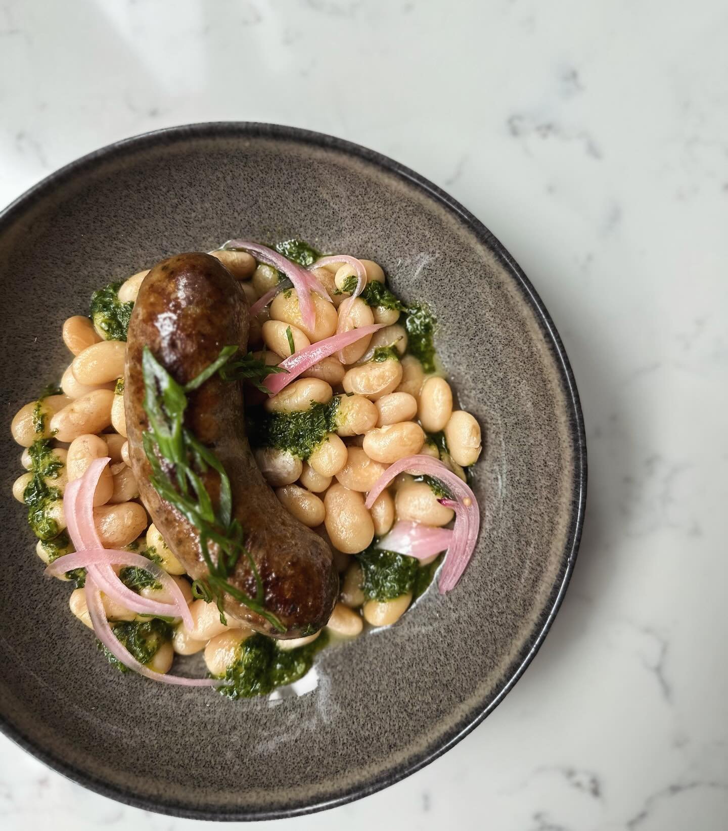 Housemade pork sausage with white beans, pickled red onions &amp; chimichurri sauce - not your typical #franksandbeans 😉

#pork #itdoesabodygood #fenwayfinds #sausagegoalz #nath&aacute;liewinebar #bostonfoodies #winebarvibz #thisishowwedoit #ticktic