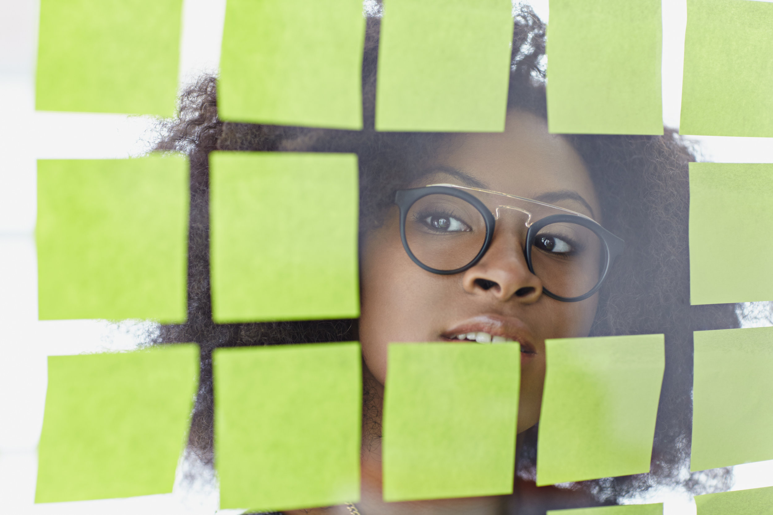 photodune-15095119-portrait-of-a-business-woman-with-an-afro-behind-sticky-notes-in-bright-glass-office-xxl.jpg
