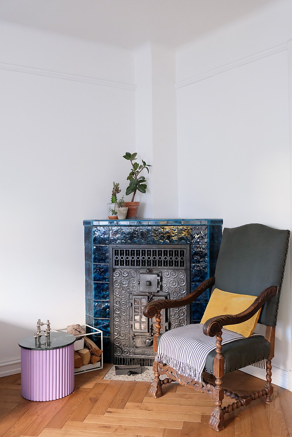  The original fireplace covered in lovely old glazed blue tiles. The chair, which is fit for a king, has been toned down with a more neutral cloth. 