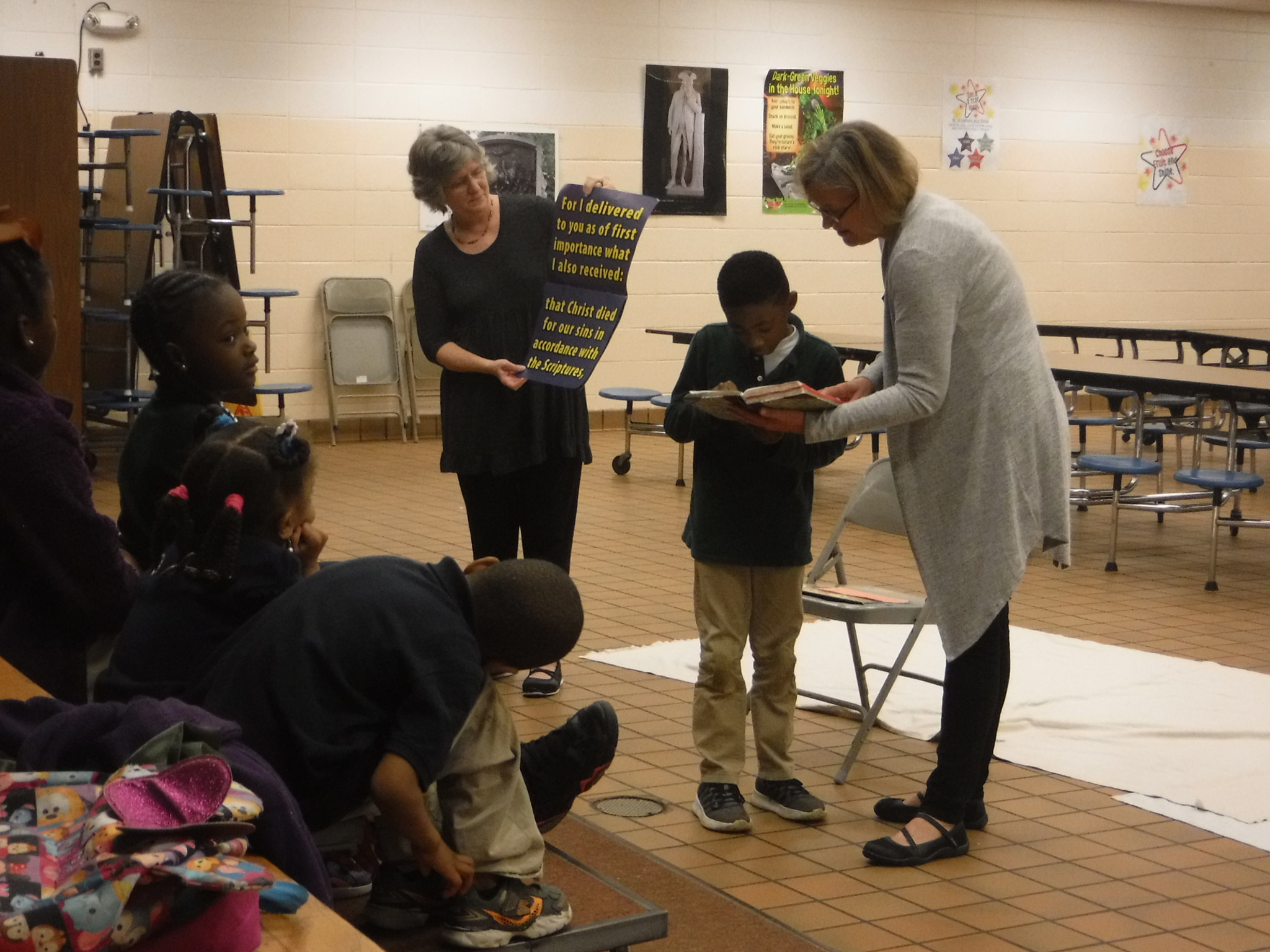  Karen Blake and Pam Jernigan of Grace Presbyterian Church teach Ephesians 2:8 and 9 to students at Dozier Elementary  Good News Club® . 