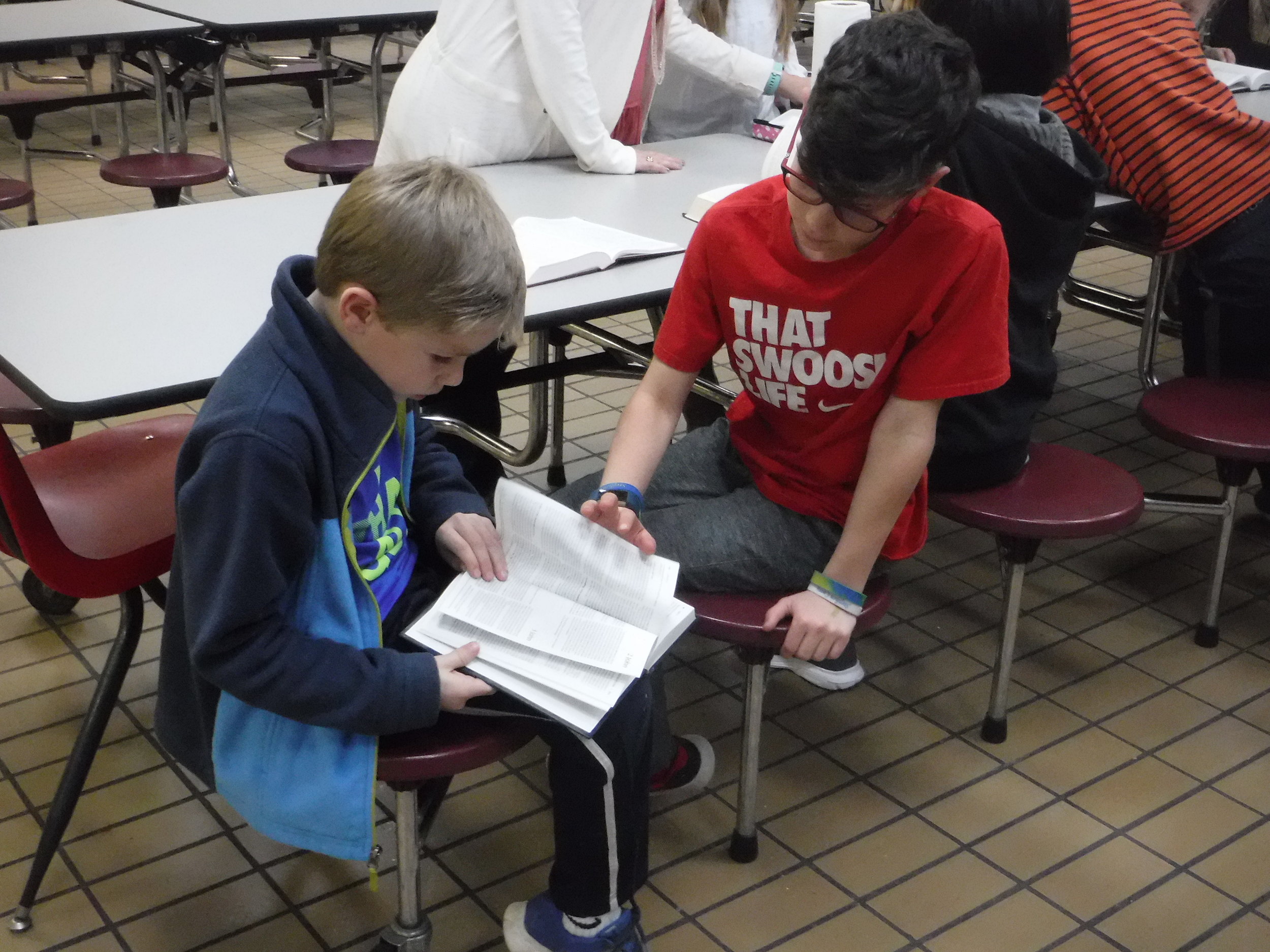  Students help each other find Scripture at Eclectic Elementary  Good News Club® . 