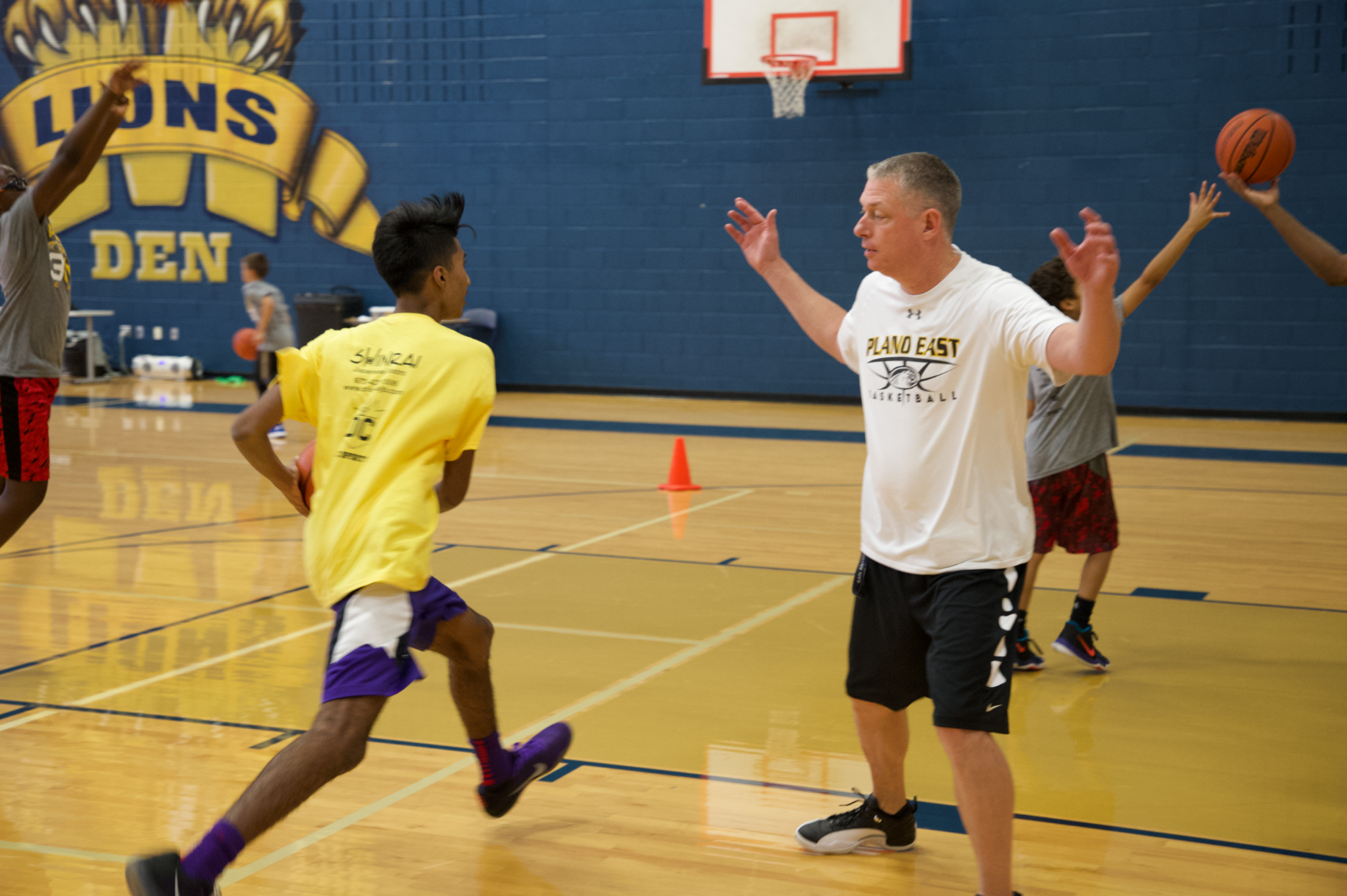 Coach Derrick Richardson works with a camper to improve his Euro step intended to allow an offensive player to evade a defender with a change of direction.