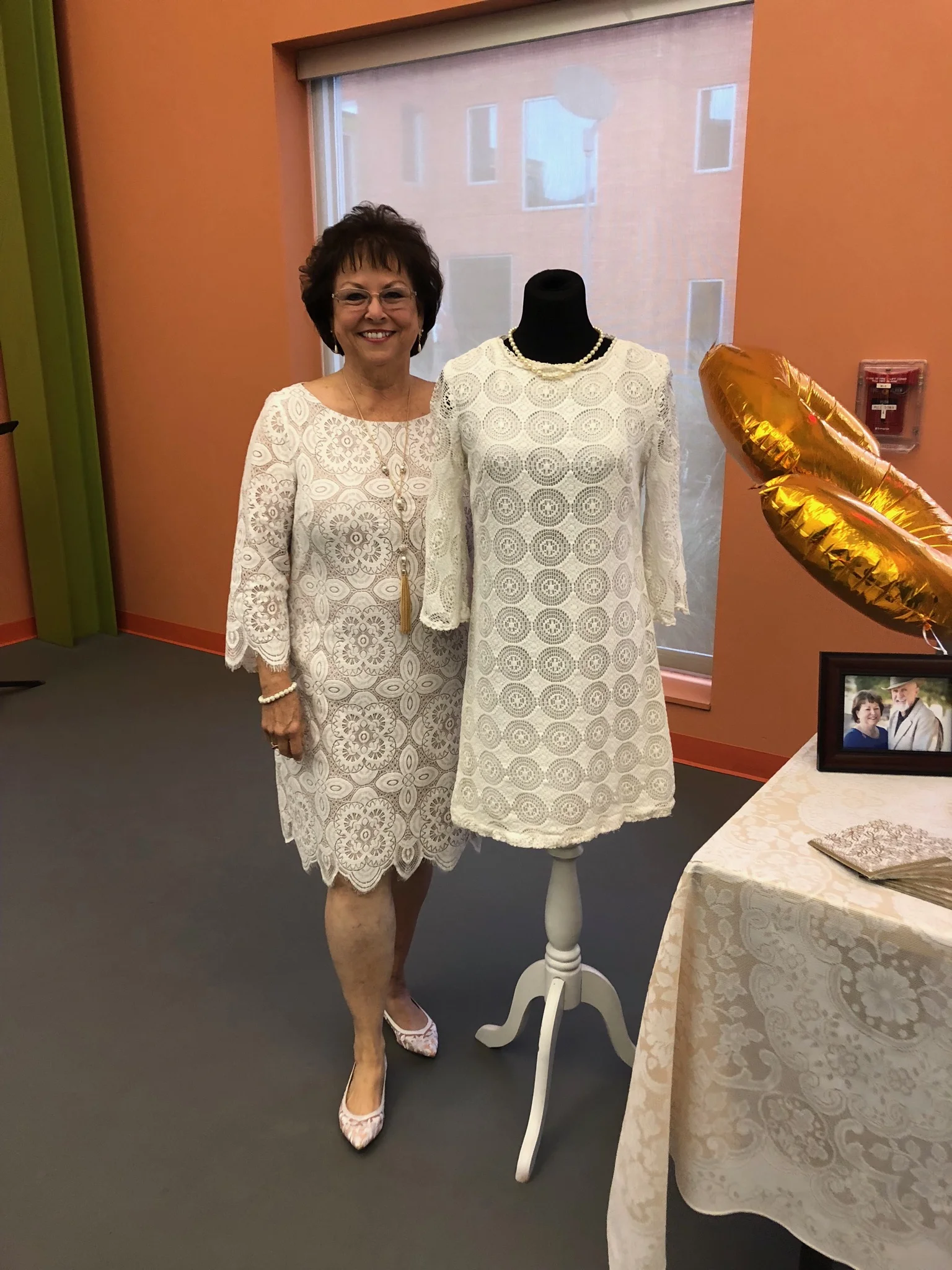 Vickie Tucker standing next to her wedding dress at their 50thanniversary party.