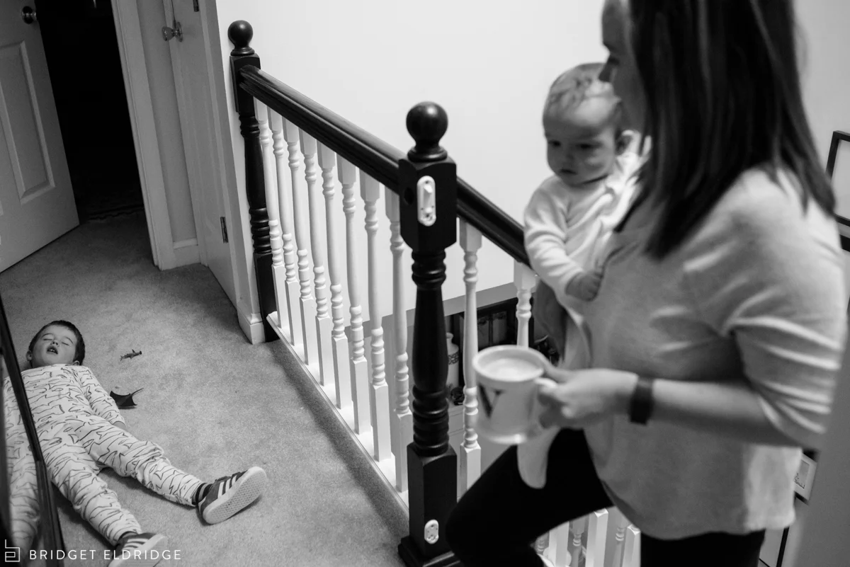 little boy pretends to be sleeping as mom comes upstairs