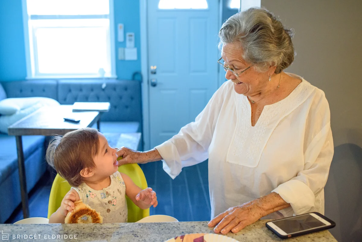 baby smiles at grandma in the kitchen