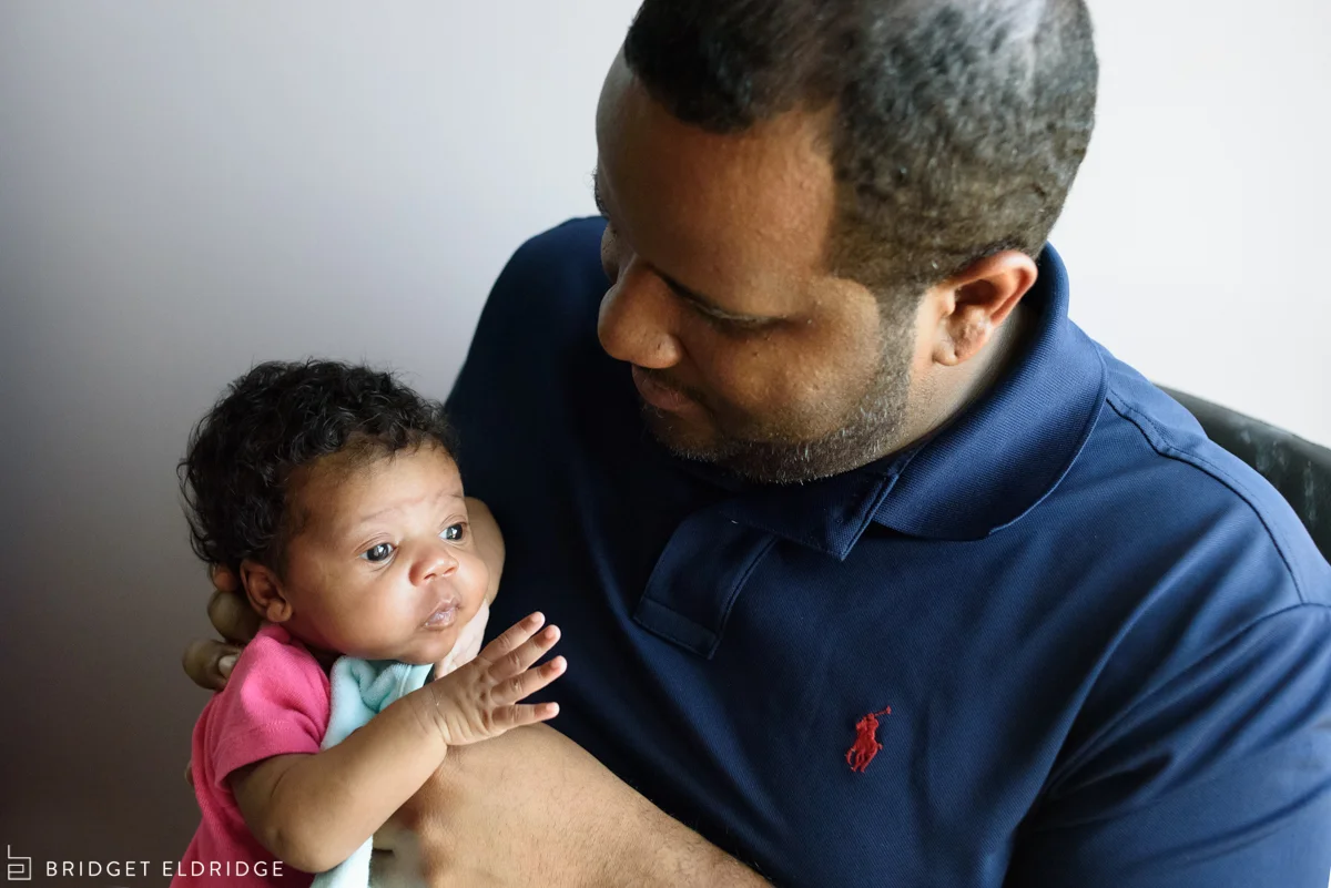 dad takes care of newborn daughter