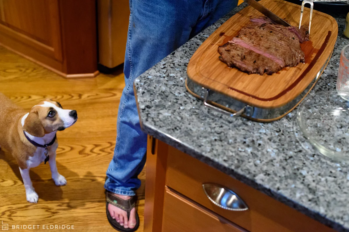 dog watches on as grandfather cuts meat