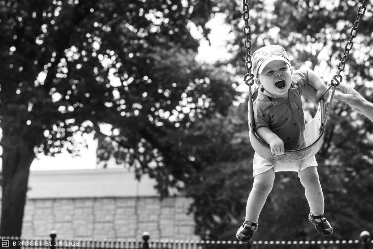 Dad pushes his son on a swing at a park on Capitol Hill.