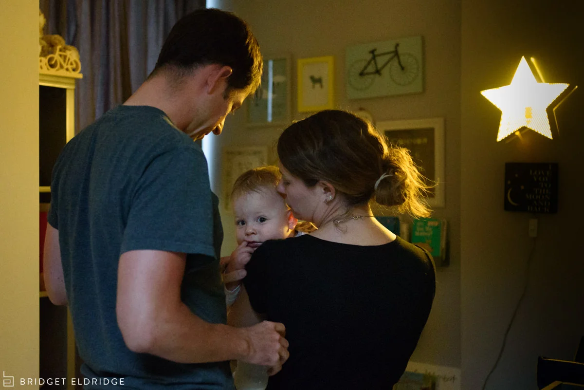 Mom and dad say goodnight to their baby.