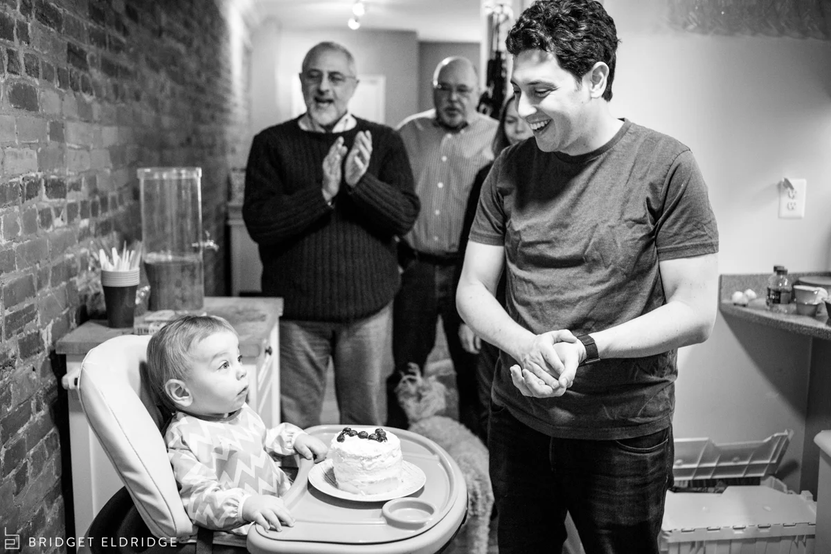 dad laughs as the family sings happy birthday