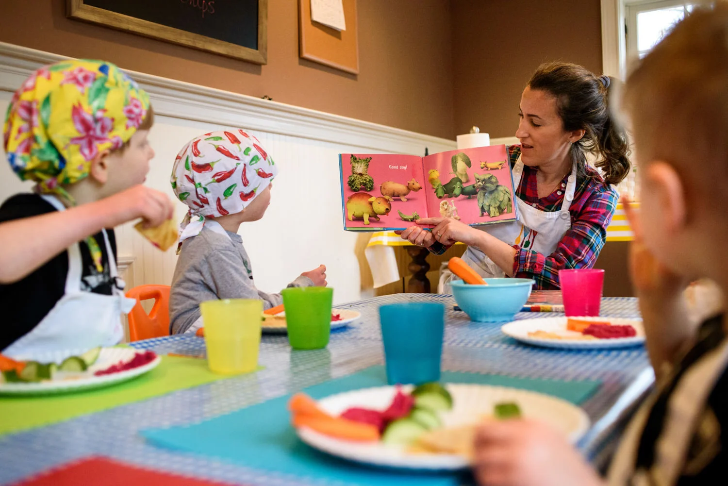 cooking teacher reads a book about food as the kids eat the pink hummus that they made