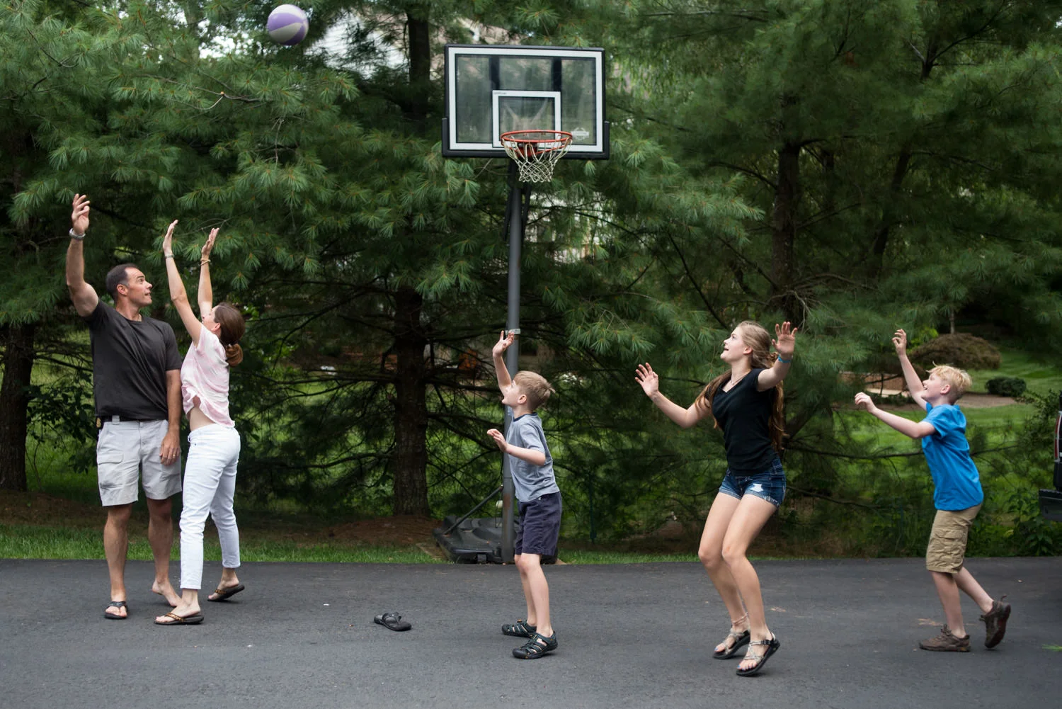 dad throws a basketball while mom blocks him