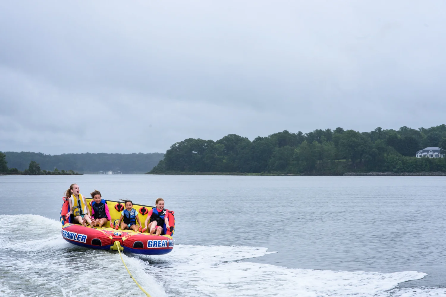 girls ride a raft on the back of a boat