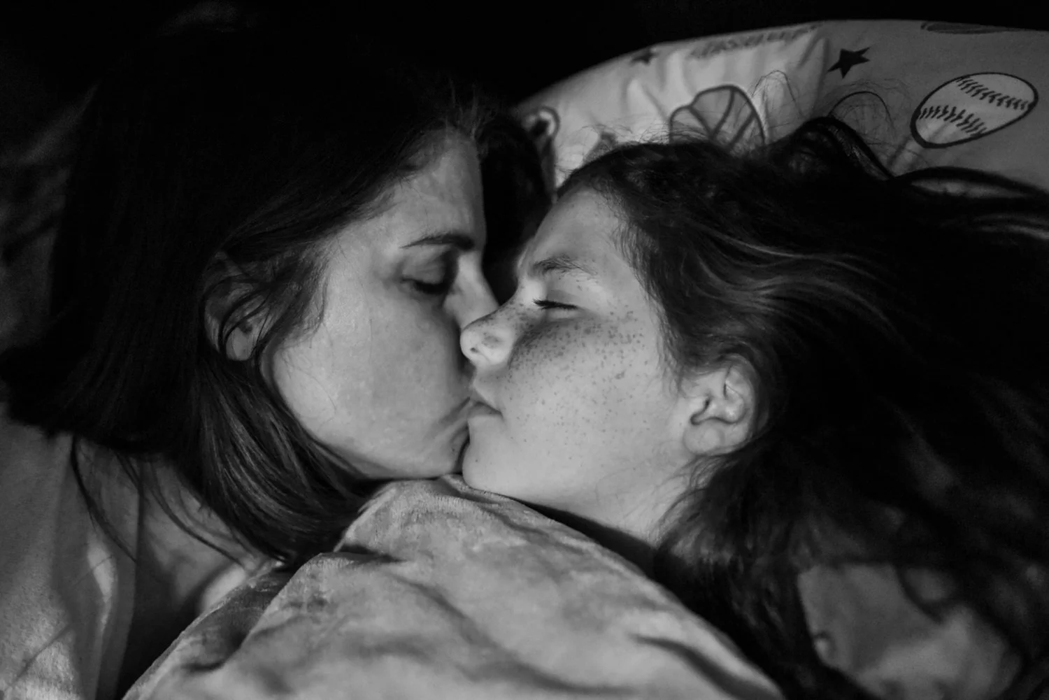 mom kisses her daughter goodnight