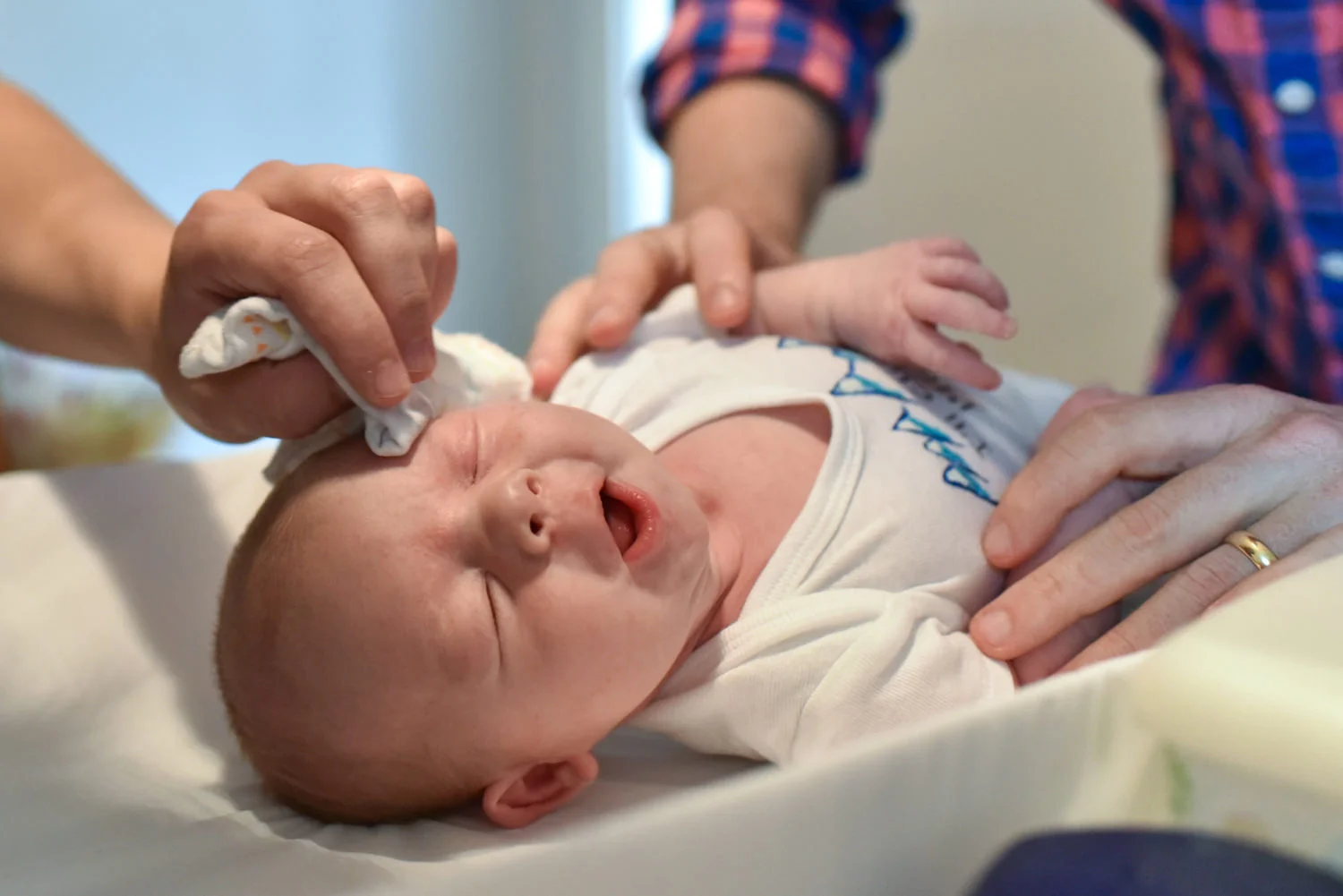 mom wipes newborn’s face