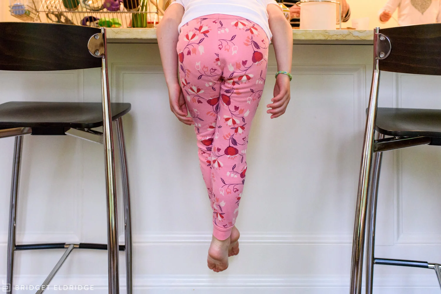 girl hangs off the kitchen counter