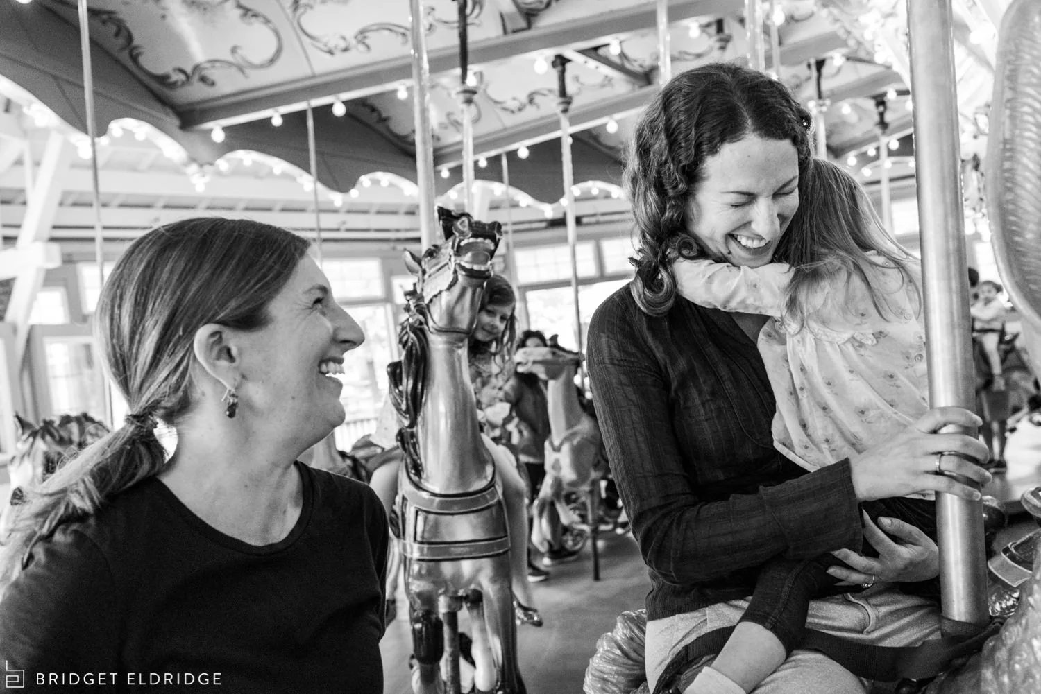 sisters laugh on the carousel at glen echo park
