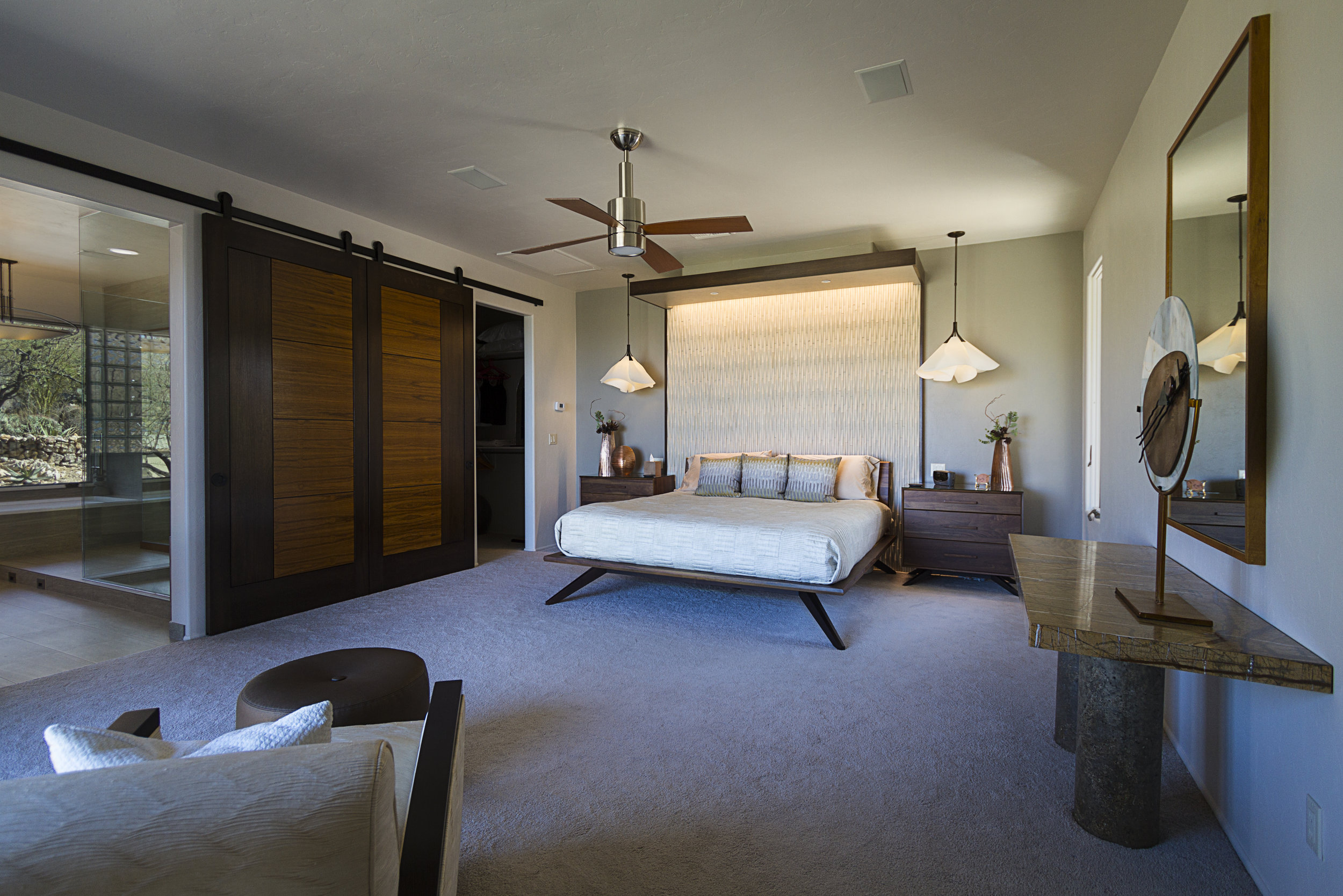  A pair of custom wood sliding barn doors grace the far wall. The doors  are constructed of rift-sawn white oak with teak panels. When closed,  they hide the entry to the Master Bathroom and walk-in-closet.   