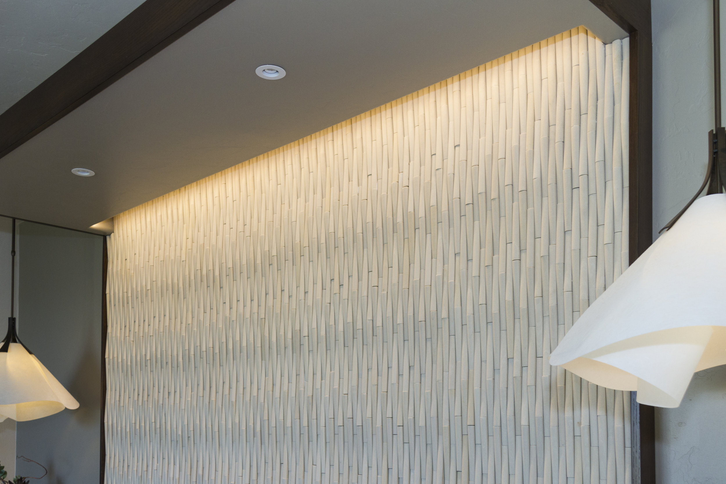  A slot at the back of the canopy washes light down the Island Stone  headboard. Additional lights provide for nighttime reading in bed.   