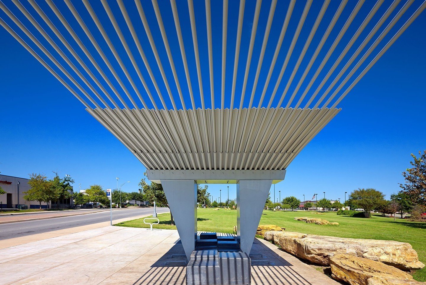 Two crisscrossing canopies composed of thin steel rods nested inside larger tubes extend to either side like the wings of a bird. #VIABusStop #MiroRiveraArchitects #MRAProjectoftheWeek 📷 @drorbaldingerphotographer