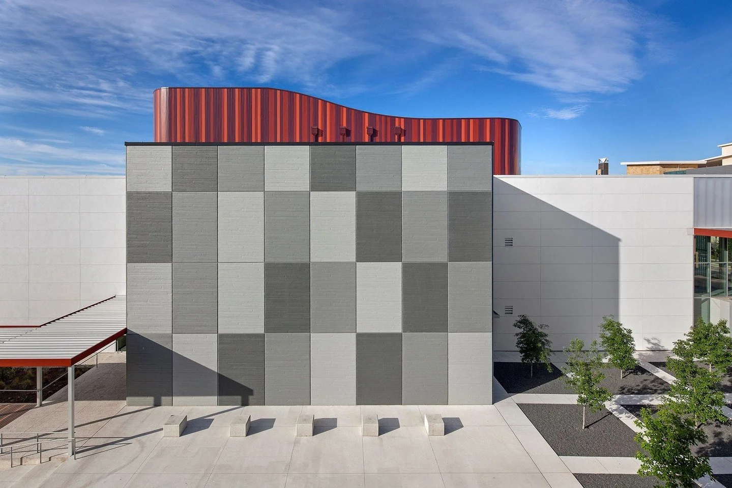 Great care was given to foster active, dynamic street edges&mdash;making the life and activity within visible from the street and vice versa. A landscaped plaza and amphitheater are open to the public, while a ribbon-like aluminum and steel trellis w