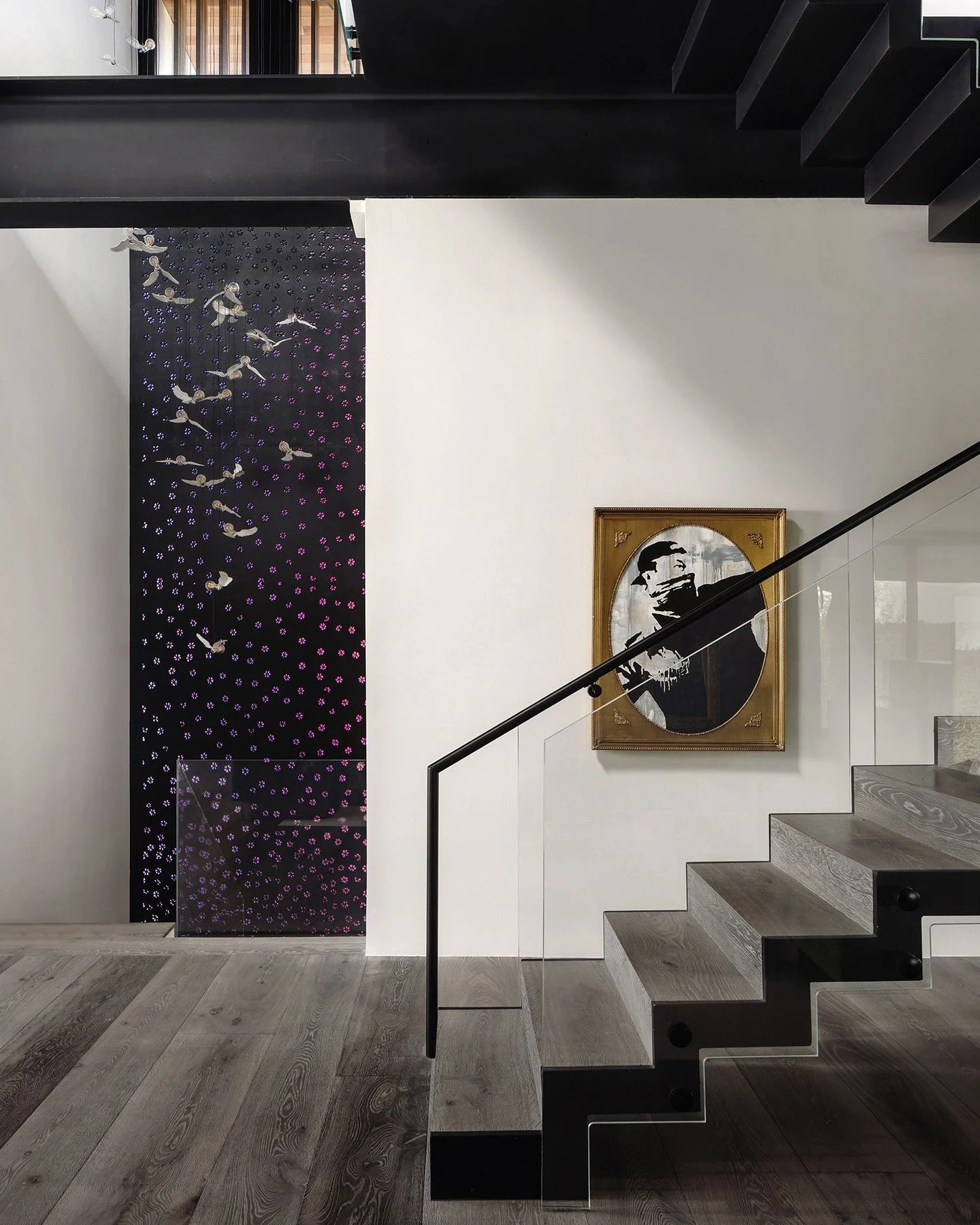 A steel staircase with glass railings at the #PingPongResidence leads from the game room to the floor above, passing through a large cutout in the floor plate framed by exposed steel beams. #MiroRiveraArchitects #MRAProjectoftheWeek 📷 @thevuvobandit