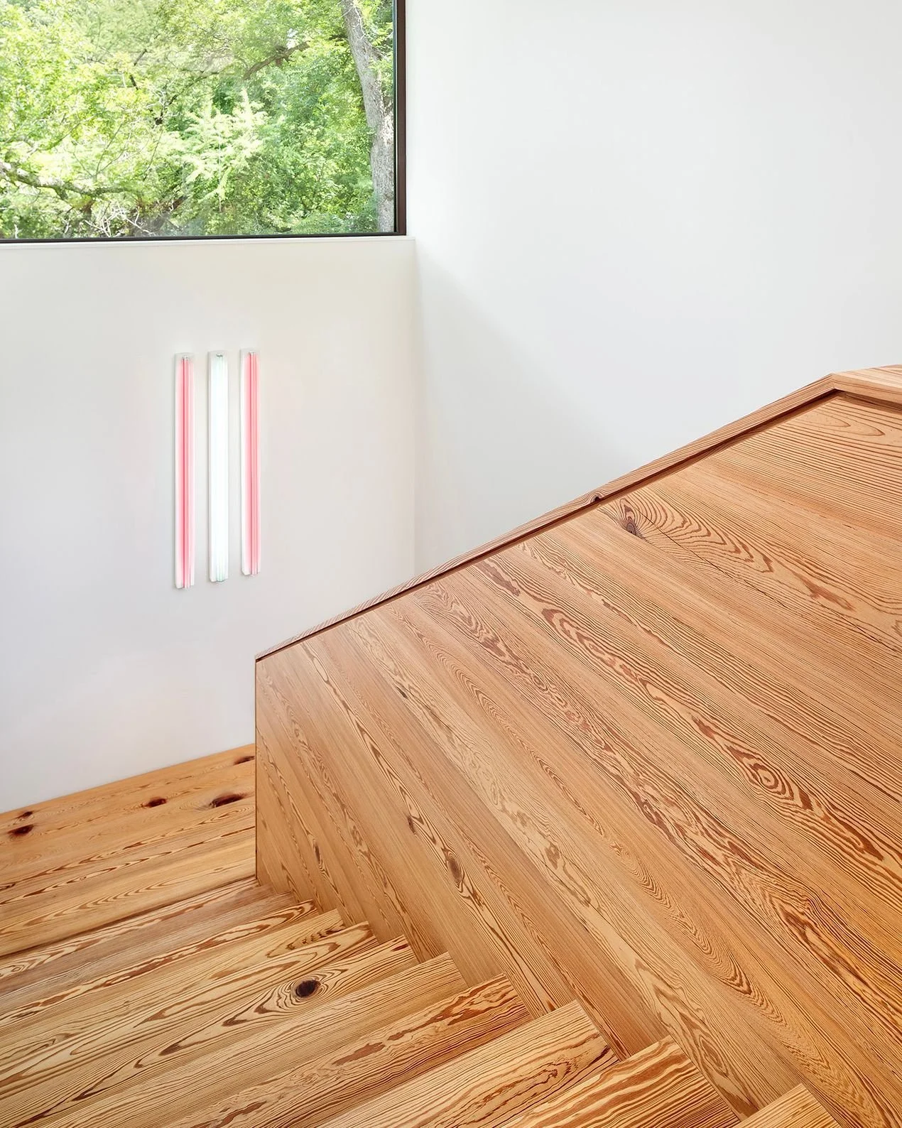 Finished with the same reclaimed long-leaf pine as the floors, the stairs at the #RiverHillsResidence are bathed in light from a clerestory window above a fluorescent artwork. #MiroRiveraArchitects #MRAProjectoftheWeek 🔨 @classicconstructors 📷 @cas