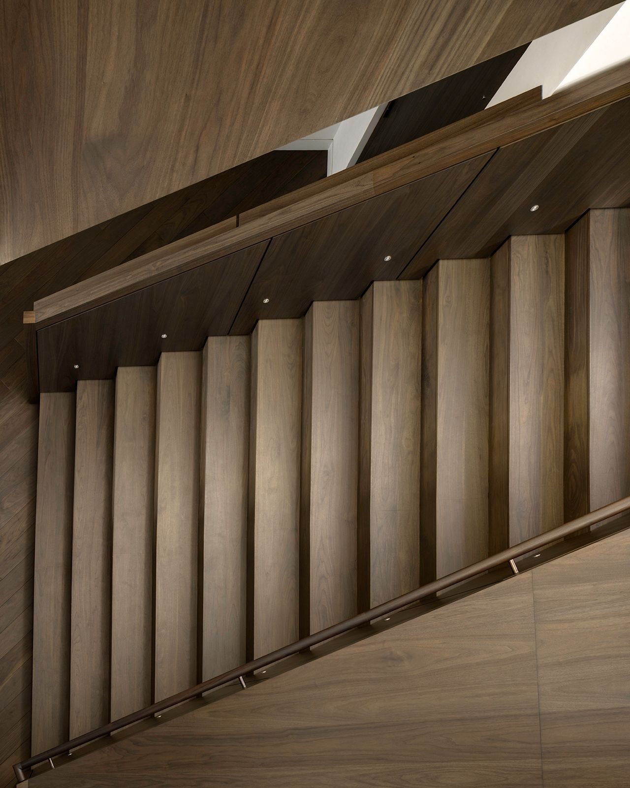 Spanning three stories, the plain-sawn walnut staircase at our #WhitePineResidence features angled planes that create interesting effects in perspective. #MiroRiveraArchitects #MRAProjectoftheWeek 🔨 Craig Construction 📷 @rafaelgamo