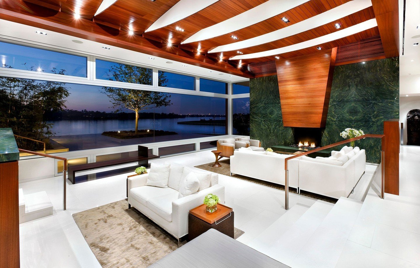 In the great room, a large window framing the lake view is butt-glazed, providing an uninterrupted panoramic vista. Furniture divides the great room into two distinctly scaled spaces. #LakeshoreResidence #MiroRiveraArchitects #MRAProjectoftheWeek 🔨 