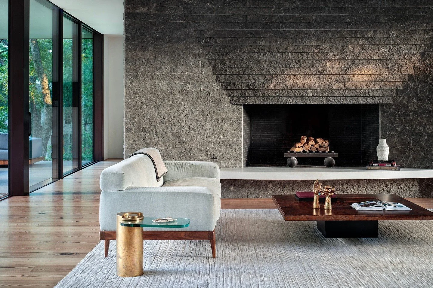 As temperatures drop across the country, we're sharing several of our favorite fireplace designs, starting with the #RiverHillsResidence. Surrounded by bands of stacked and angled charcoal limestone, the hearth itself is made from honed limestone. #M