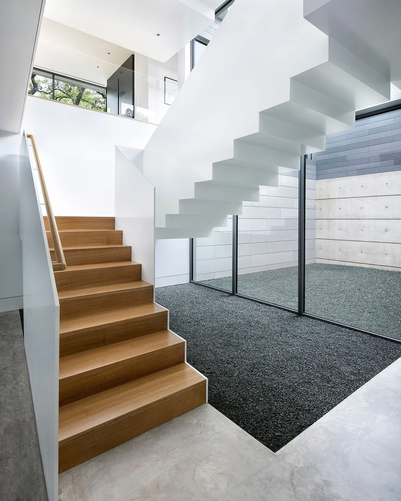 A central staircase anchors the layout, with rooms and hallways unfolding from it on every floor. A wall of glass separates the stairs from a triple-height courtyard, illuminated from above by an amorphous oculus. #VistaResidence #MiroRiveraArchitect