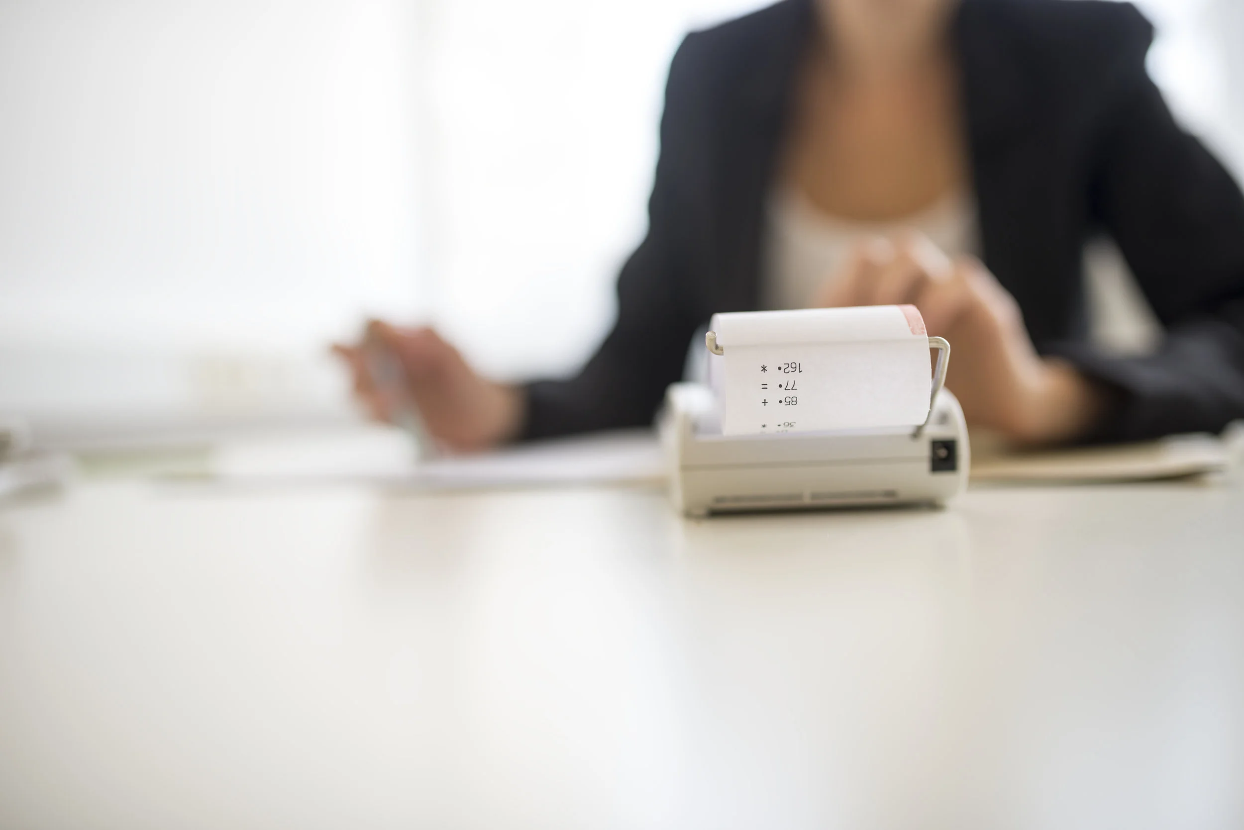 photodune-20452250-adding-machine-in-foreground-with-obscured-worker-xxl.jpg