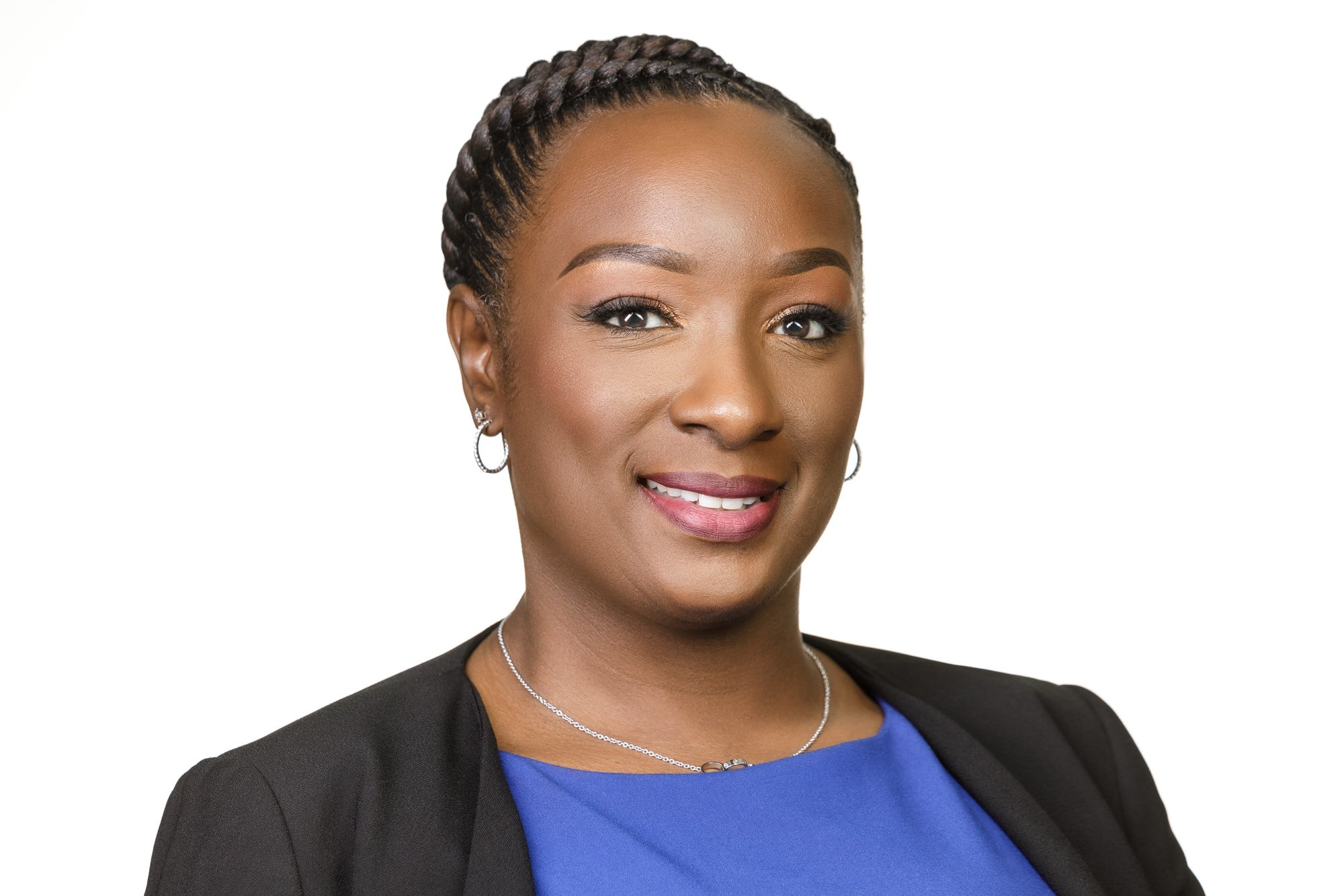 Close-up of a smiling businesswoman wearing a blue blouse/shirt and black blazer on a white background.
