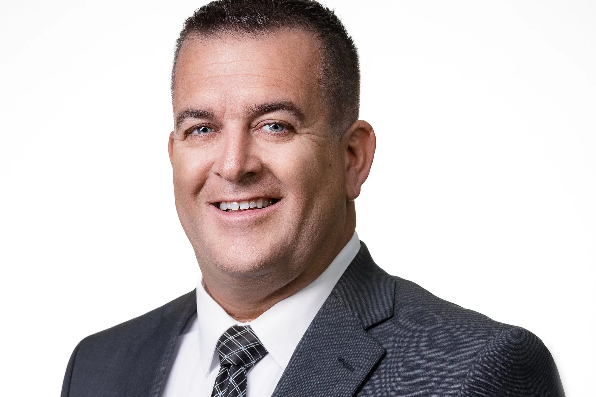Smiling man in suit and tie against white background