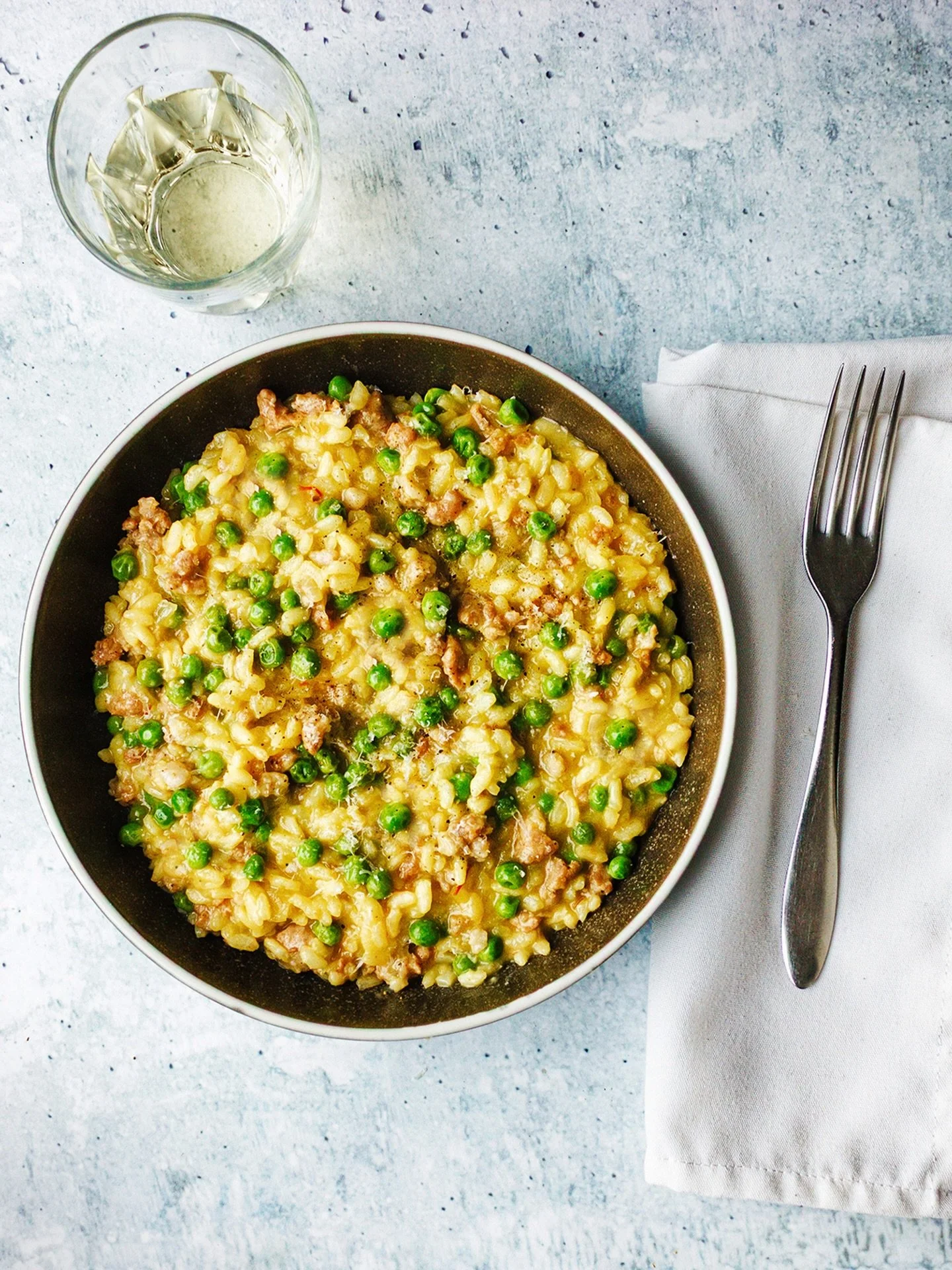 Midweek risotto. A couple of really good, spicy Italian sausages, peas foraged from the freezer, a pinch of saffron in the stock. 18 minutes of massaging the starch out of and the flavour into some vialone nano.

Add the couch, an old movie (They Liv