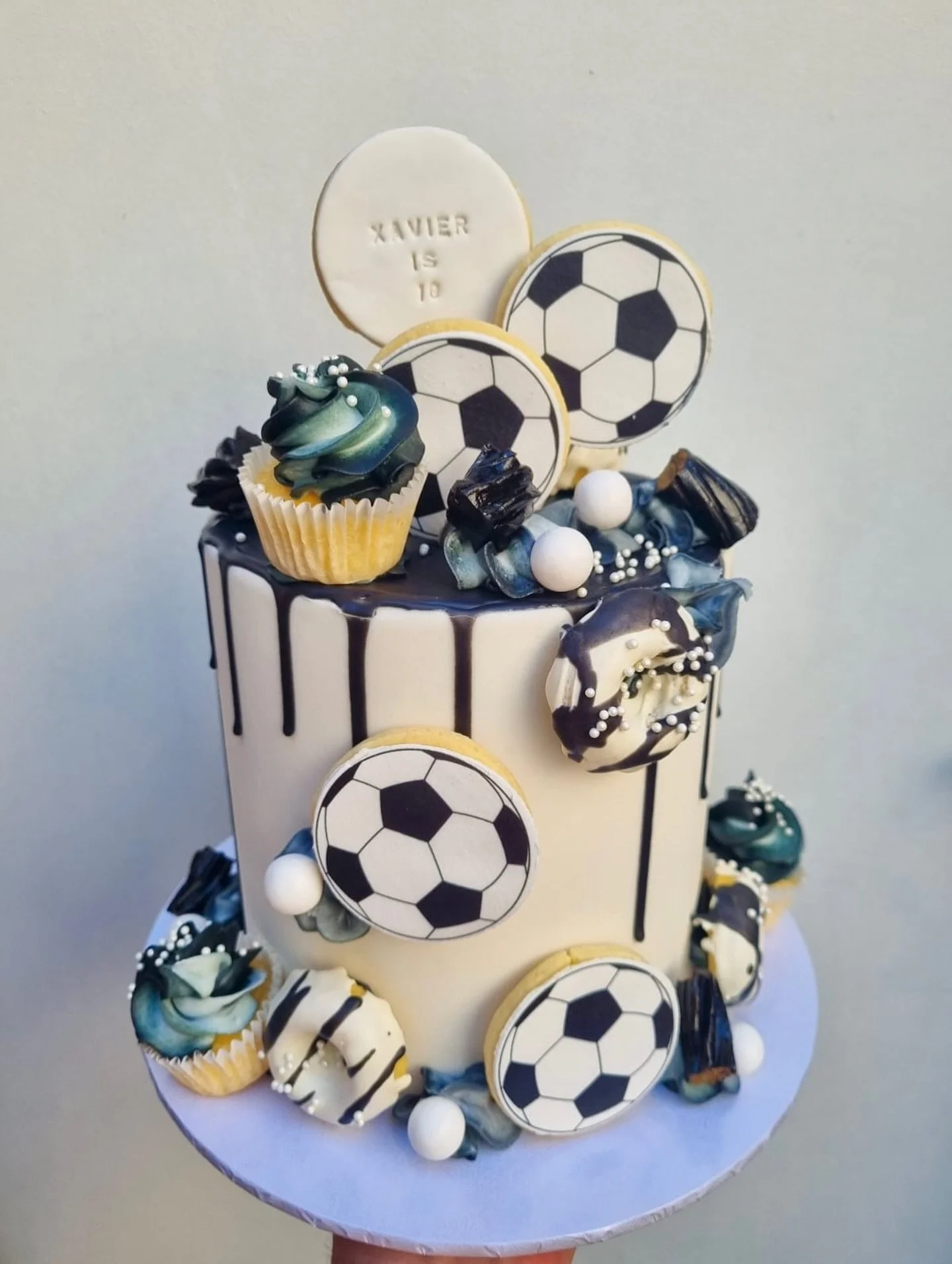 ⚽️🎂 Goal-getter vibes only!
This soccer-themed birthday cake is scoring serious style points 🖤🤍
Complete with mini cupcakes, drizzle details, and edible soccer-ball cookies &mdash; it&rsquo;s a total 10 out of 10!

#customcake #soccerbirthday #mel