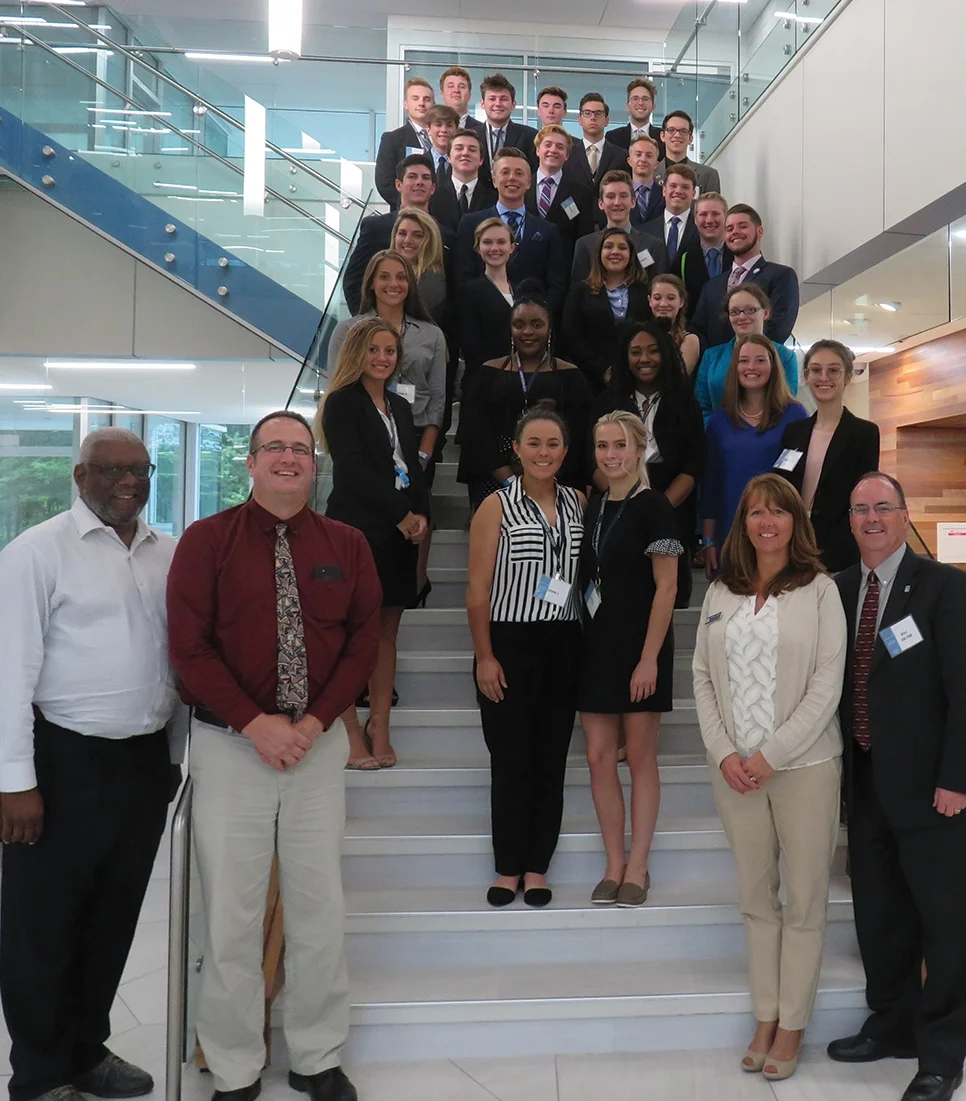 The members of LAB Camp's 2018 class pose with their instructors inside the DeVos Graduate School building.