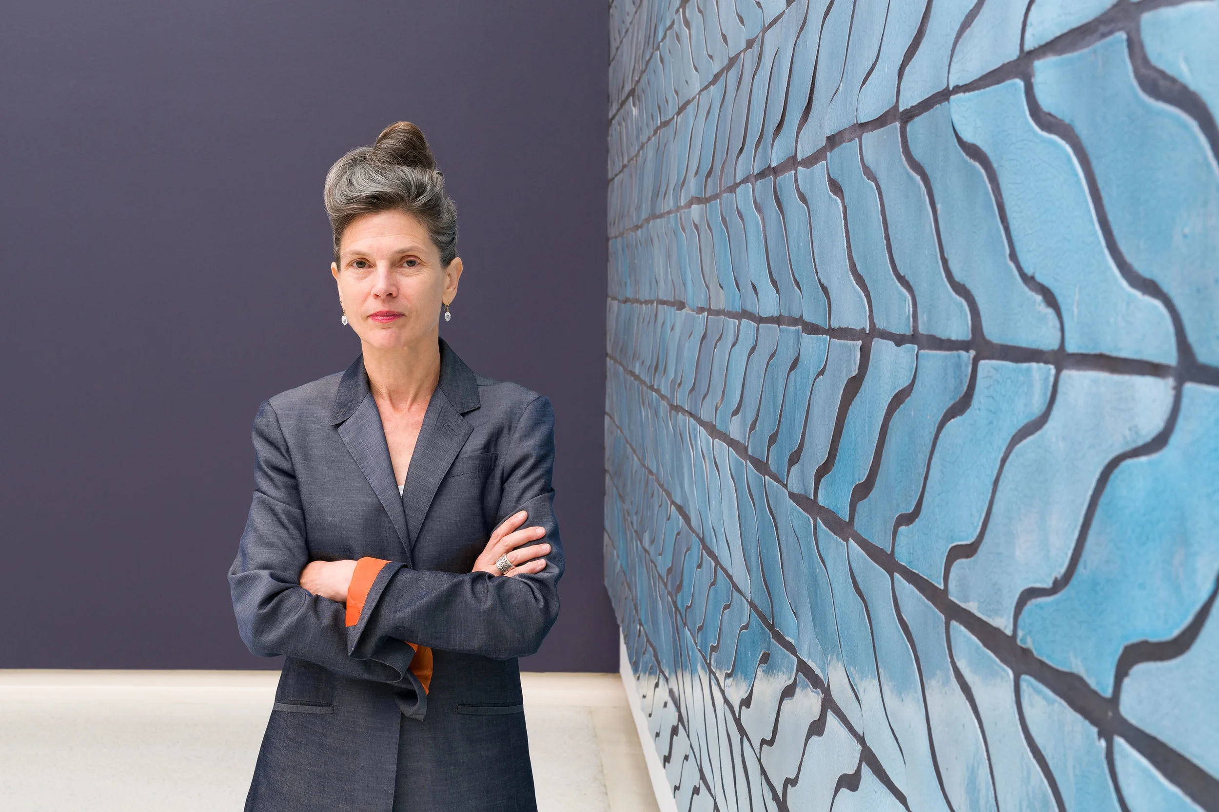 Ingrid Schaffner, curator of the 57th Carnegie International in front of Sarah Crowner’s Wall (Wavy Arrow Terracotta) , 2018. © Carnegie Museum of Art, Pittsburgh. Photo: Bryan Conley.