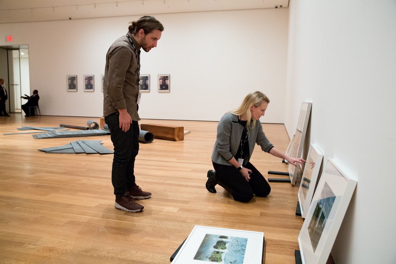 Fisher with Curatorial Assistant Luke Baker at MoMA with works by firm Superstudio for the 2016 exhibition From The Collection, 1960–1969 . Image by Claudio Papapietro, courtesy The Wall Street Journal.