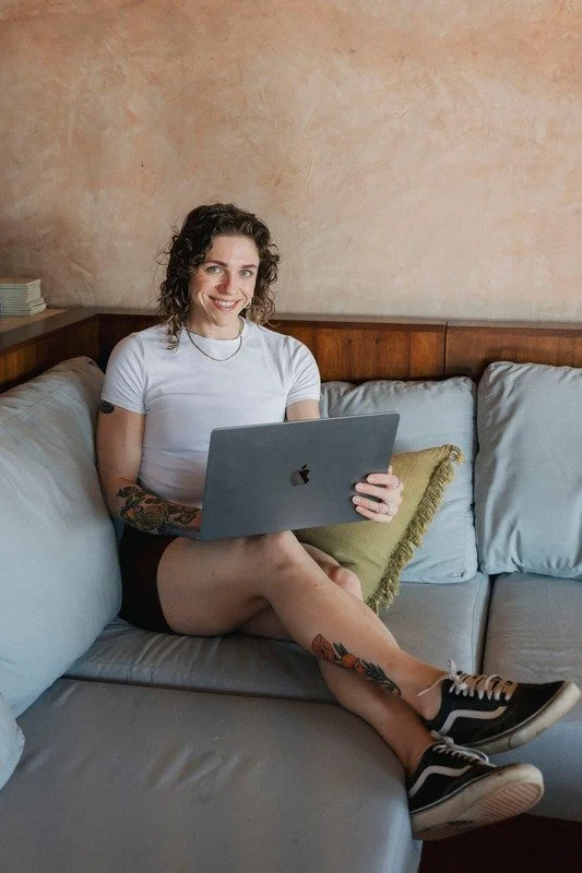 Jilda sitting on a couch using her laptop