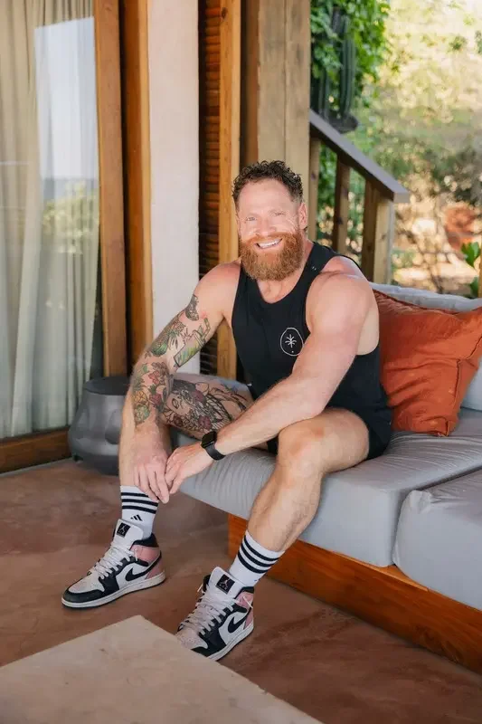 Coach Zach sitting on a chair and smiling warmly