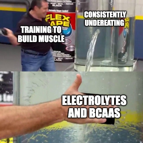Meme showing a man trying to plug a large water leak labelled ‘consistently undereating’ while focusing on ‘electrolytes and BCAAs’, illustrating the mismatch between training to build muscle and inadequate overall food intake.